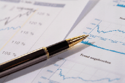 Picture of a pen and financial charts